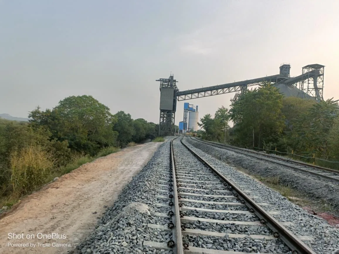 Curved siding track leading to a conveyor structure