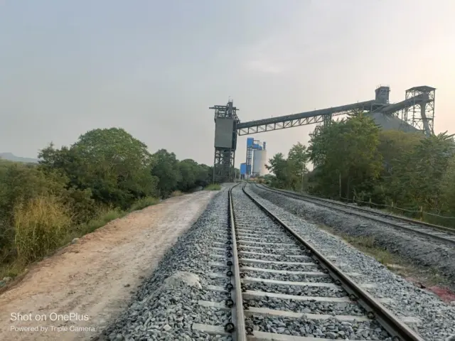 Curved siding track leading to a conveyor structure